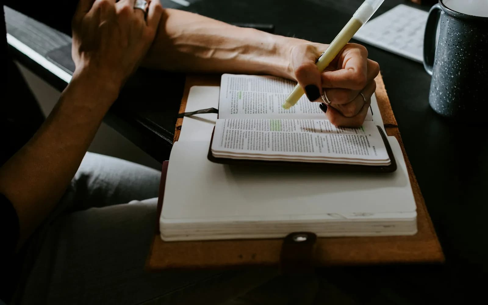 person holding white pen writing on white notebook